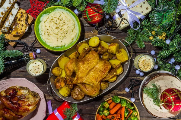 Geleneksel yiyeceklerle, fırınlanmış jambonla, tavukla, kızarmış havuçla, Brüksel lahanasıyla, patatesle, Noel dekoruyla ve hediyelerle dolu Noel yemeği masası.