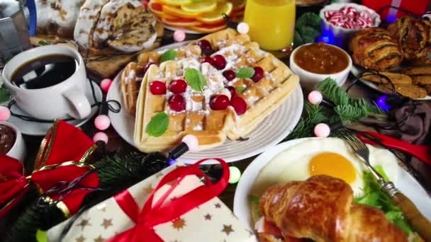 伝統的な食品パンケーキ ベルギーのワッフル 目玉焼き クロワッサン 盗まれた クッキー オレンジジュースとコーヒー シナモン粥とクリスマスの朝の朝食やブランチテーブル — ストック動画
