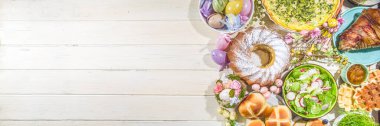 Bayram yemeği, Paskalya brunch 'ı. Geleneksel Paskalya yemekleri aile sofrasında - pişmiş et, kiş, bahar salatası, kek, renkli yumurta, sıcak haç çörekleri