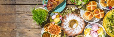 Bayram yemeği, Paskalya brunch 'ı. Geleneksel Paskalya yemekleri aile sofrasında - pişmiş et, kiş, bahar salatası, kek, renkli yumurta, sıcak haç çörekleri
