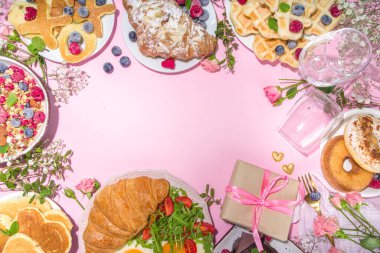 Sevgililer Günü brunch menüsünde çeşitli kahvaltı ve öğle yemekleri, waffle, kruvasan, kek, çörek, dut, patates kızartması, çırpılmış yumurta, krep, pembe arka plan fotokopi alanı