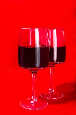 Sevgililer günü hediye kutusu ve şarap kadehleri, kırmızı arka plan üzerinde altın kalp dekoru olan fotokopi alanı