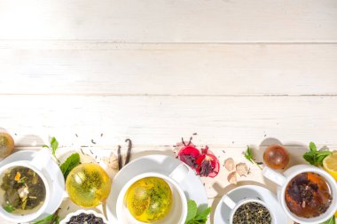Çeşitli çay topu bombaları. Kurutulmuş çay, fincanlar, limon ve nane içeren farklı çay topları, üst görünüm kopyalama alanı. Modern çay çeşitleri