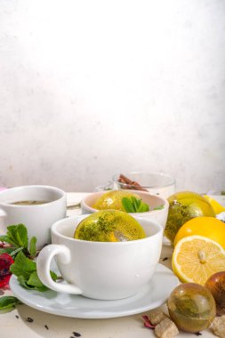 Çeşitli çay topu bombaları. Kurutulmuş çay, fincanlar, limon ve nane içeren farklı çay topları, üst görünüm kopyalama alanı. Modern çay çeşitleri