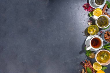 Çeşitli çay topu bombaları. Kurutulmuş çay, fincanlar, limon ve nane içeren farklı çay topları, üst görünüm kopyalama alanı. Modern çay çeşitleri