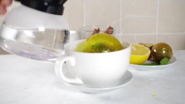 用时髦的现代茶球炸弹泡茶 茶球与干茶 柠檬和薄荷 与经典的白杯 顶视图复制空间 — 图库视频影像