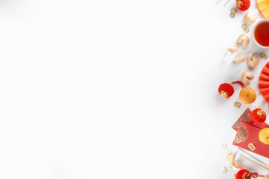 Çin 'in yeni yıl geçmişi. Geleneksel Çin Yeni Yıl dekoruna sahip kırmızı ve sarı düz yatak, dileklerle dolu zarflar, altın sikkeler, yelpazeler, Çin fenerleri, portakallar ve çay.