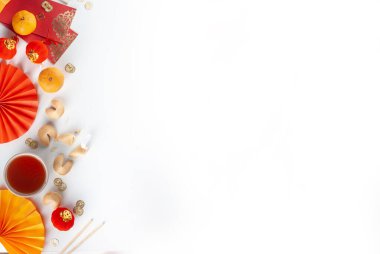 Çin 'in yeni yıl geçmişi. Geleneksel Çin Yeni Yıl dekoruna sahip kırmızı ve sarı düz yatak, dileklerle dolu zarflar, altın sikkeler, yelpazeler, Çin fenerleri, portakallar ve çay.