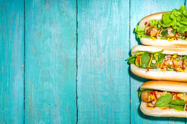 自家製のビーガンホットドッグ 白い肉ソーセージ 新鮮な野菜 ソース 夏の太陽の下でホットドッグが点灯青い木製の背景コピースペース — ストック写真