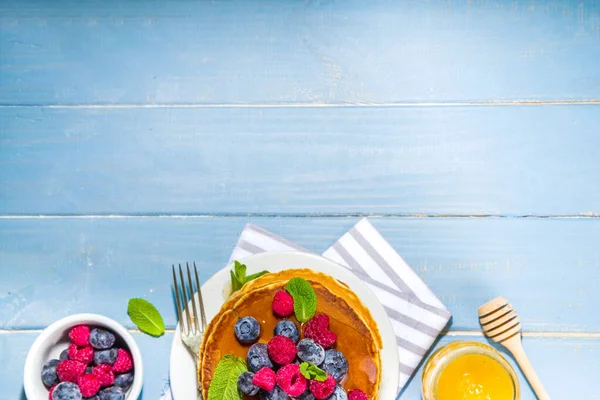 Mutfak masasında taze böğürtlen ve şuruplu leziz geleneksel Amerikan krepleri tabağı.