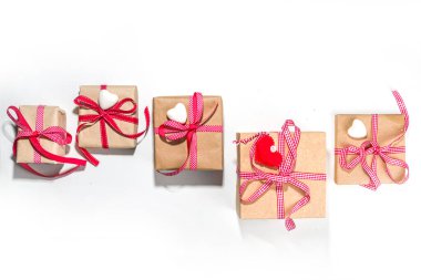 Sevgililer Günü tebrik kartı geçmişi. Çeşitli sevgililer günü hediye kutuları, el işi, kalp, kırmızı kurdele, beyaz arka planda.