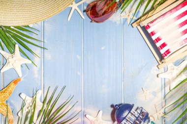 Yaz tatili ve güverte sandalyesi, Lifebuoy, kokteyl, tropikal yapraklar, kum, güneş gözlüğü, deniz kabuğu deniz yıldızıyla seyahat. Mavi güneş ahşap arkaplan kopyalama alanını aydınlattı