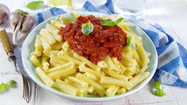 イタリアのキャセキュリティパスタを調理 トマトマリナラソースと 乾燥ハーブやバジルの葉 白いタイルの背景 — ストック動画