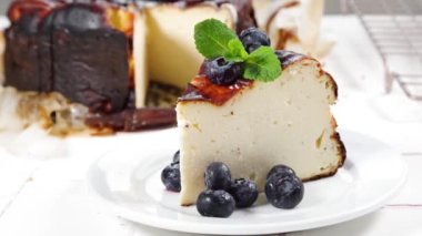 Ev yapımı yanık Bask peynirli keki, yanmış Bask peynirli kek, çilek dekoru ve tüm pasta. Tarta de Queso İspanyolca tarif kavramı