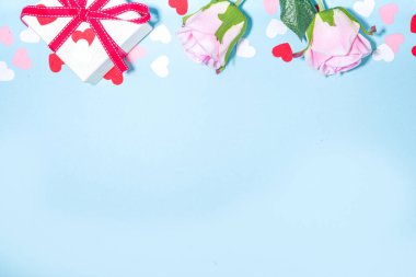 Sevgililer Günü basit tebrik kartı düzlüğü. Sevgililer Günü arka planı kırmızı, pembe, beyaz kalpler, pembe güller, hediye kutusu ve metin için boş not defteri, üst çerçeve çerçeve fotokopi alanı açık mavi arkaplan