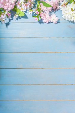 Merhaba bahar konsepti. Bahar tatili tebrik kartı suni çiçekli sade yassı arka plan açık mavi ahşap bahçe masası arkaplan çerçeve fotokopi alanı üst görünüm