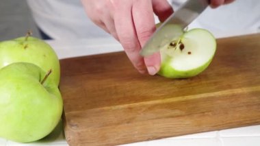 Taze elma dilimleme videosu. Kadın elleri bıçakla kesilmiş taze elma meyveleri. 