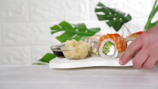 寿司配達 レストランメニューのコンセプト クローズアップビデオでは テーブルの上に寿司ロール 箸のセットを公開します — ストック動画