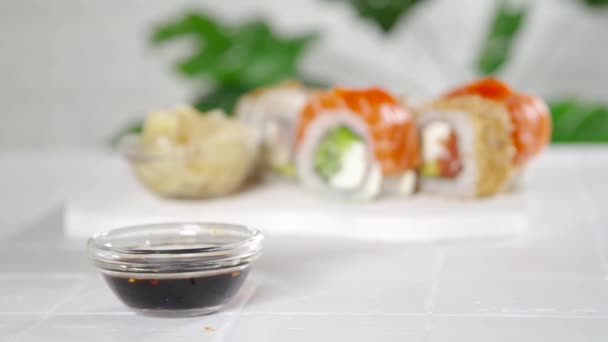 寿司配達 レストランメニューのコンセプト クローズアップビデオでは テーブルの上に寿司ロール 箸のセットを公開します — ストック動画