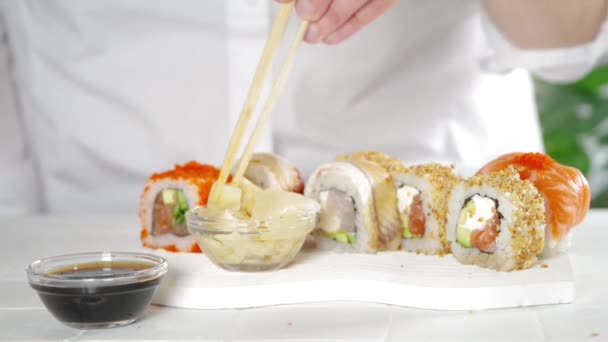 寿司配達 レストランメニューのコンセプト クローズアップビデオ 女の子食べるA古典的なセットの寿司ロール — ストック動画