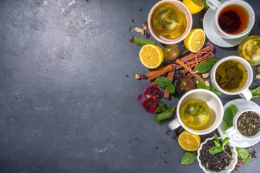Çeşitli çay topu bombaları. Kurutulmuş çay, fincanlar, limon ve nane içeren farklı çay topları, üst görünüm kopyalama alanı. Modern çay çeşitleri