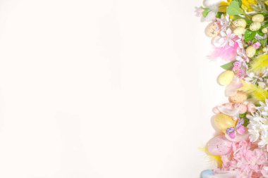 Paskalya bayramı üst görünümü düz çerçeve arkaplan, paskalya renkli yumurtalar ve bahar çiçekleri. Bahar tatili tebrik kartı arkaplanı, kopyalama alanı