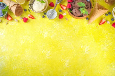 Farklı kaselerde çeşitli renkli dondurma topları, dondurma külahları ve aromalı malzemeler - şam fıstığı, böğürtlen, limon, çikolata, vanilya fasulyesi, nane. Koyu arkaplan kopyalama alanı