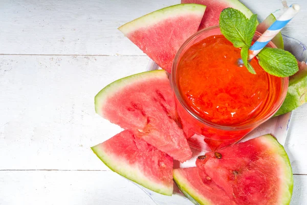 冰凉的饮料 西瓜摇动莫吉托或果汁 配上新鲜西瓜片 放在白色木制桌子上的一个小盘子里 — 图库照片