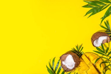 Şapkalı, mangolu, hindistancevizli, tropikal meyveli, palmiye yapraklı, kulaklıklı bir tropik yaz. Yaz tatili düzlüğü, tatil gezisi konsepti. Metin için en üst görünüm kopyalama alanı