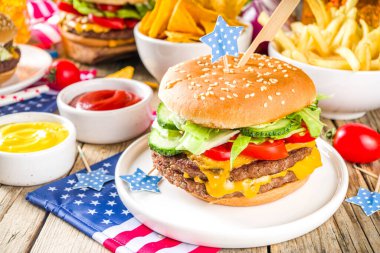 4 Temmuz Bağımsızlık Günü 'nü kutluyoruz. Geleneksel Amerikan Anma Günü pikniği hamburger, patates kızartması ve abur cubur, yaz pikniği ve bbq konsepti, eski ahşap arka plan. 