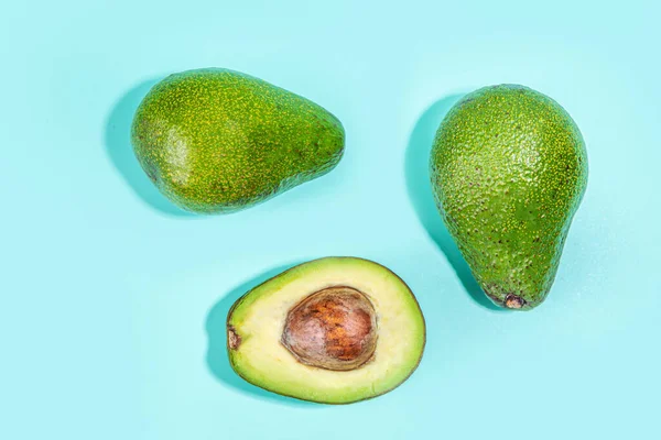 Hele Gesneden Avocado Een Blauwe Platte Achtergrond Eenvoudig Avocado Patroon — Stockfoto