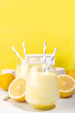 Limonlu kremalı meyve suyu, yoğurtlu milkshake, beyaz sarı arka planda taze limonlu ekşi tatlı içecek fotokopi alanı.