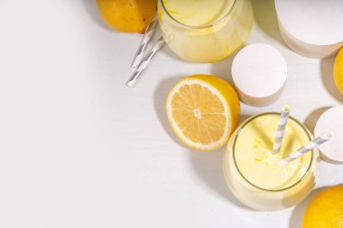 Creamy lemon fruit smoothie, yogurt ar milkshake, Sour sweet drink with fresh lemons on white yellow background copy space clipart