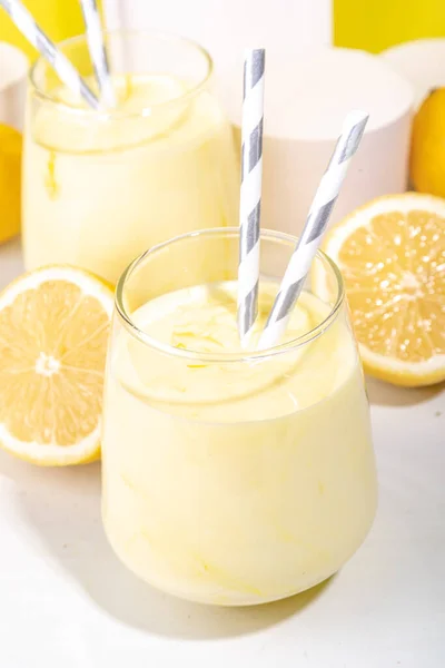 奶油柠檬果浆 酸奶和奶昔 在白色的黄色背景中加入新鲜柠檬的甜饮料 — 图库照片