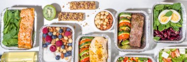 Sağlıklı yemek menüsü, kurye yemek teslimatı beslenme çantası. Biftek eti, tavuk fileto, balık ve sebzeler paketlerde. Günlük yemek diyet planı teslimatı, paket servisi, online sipariş konsepti.