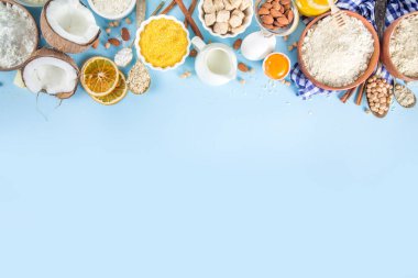 Pişirme arka plan çerçeve arka planı. Çeşitli glütensiz un ve malzemeler, tatlı ve ekmek fırını için, renkli mavi mutfak masasında çatal bıçak, yumurta, şeker, tarçın