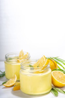 Limonlu ve adaçayı yapraklı limonlu panna cotta tatlısı. Beyaz arka planda turuncu turunç panna cotta