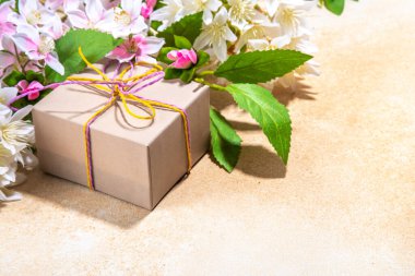 Anneler günü tebrik kartı geçmişi mevcut ve çiçekli. Şenlik kurdeleli bir hediye kutusu, 