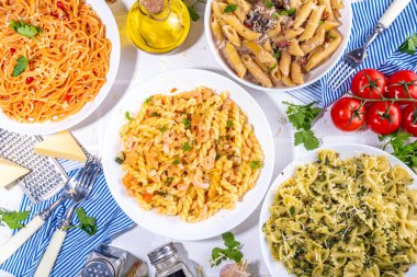 Beyaz fayanslı arka planda farklı soslu makarna seti. Spagetti, farfalle, makarna, deniz ürünleri, ıspanak, karbonara, domates soslu fusilli makarna. İtalyan yemeği, Akdeniz yemeği konsepti