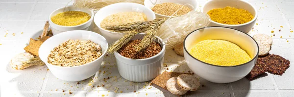 Selection of whole grains gluten free cereals. Set of various non-gluten cereals: rice, buckwheat, corn groats, quinoa, millet, oats, buckwheat, bulgur, porridge, barley, white background copy space