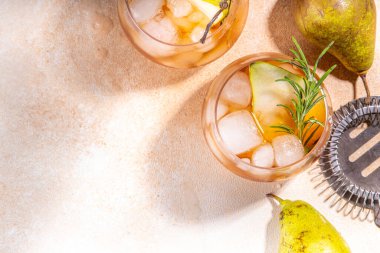 Alkollü meyve suyu, armut dilimlenmiş rom, likör, anason ve biberiye filizli soğuk armut kokteyli.