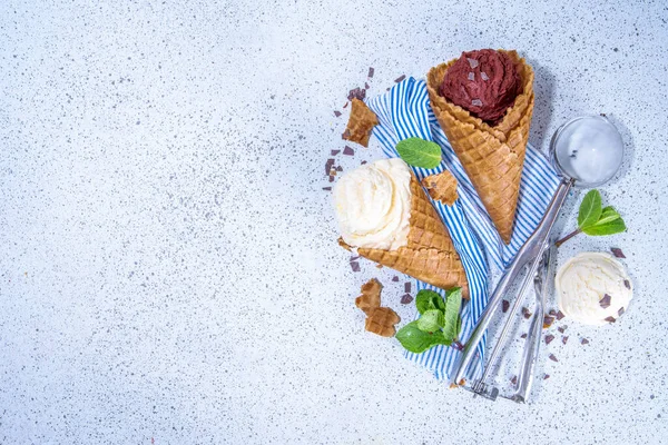 Beyaz arka planda vanilyalı ve çikolatalı dondurma. Waffle külahında klasik yaz dondurması tadı, dondurma kepçesi, çikolata ve şeker parçacıkları, yaz tatlı aroması konsepti, üst görünüm kopya alanı