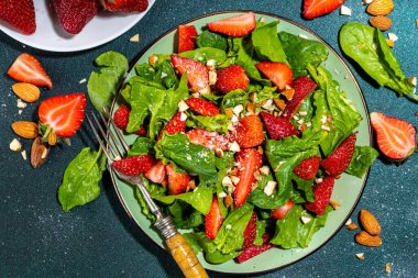 Çilek, ıspanak ve fındık salatası. Sağlıklı diyet yaz salatası, ıspanak yaprakları, doğranmış badem ve organik çilek dilimleri, kopyalama alanı.