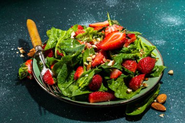 Çilek, ıspanak ve fındık salatası. Sağlıklı diyet yaz salatası, ıspanak yaprakları, doğranmış badem ve organik çilek dilimleri, kopyalama alanı.