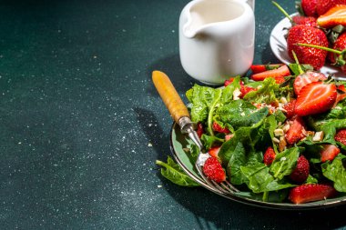 Çilek, ıspanak ve fındık salatası. Sağlıklı diyet yaz salatası, ıspanak yaprakları, doğranmış badem ve organik çilek dilimleri, kopyalama alanı.