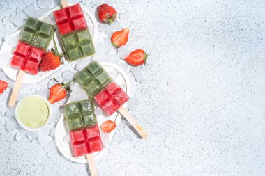 Sütsüz yeşil kibrit ve çilekli dondurma. Yeşil kibrit çay tozu ve dut suyu ile vejetaryen dondurması, beyaz beton arka planda sağlıklı organik tatlı.