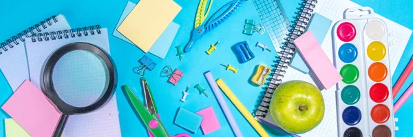 Düz bir zemin, parlak mavi arka planda renkli eğitim malzemeleri vardı. Okul konseptine geri dönelim. Okul çantasında makas, not defteri, kalem, kalem ve malzeme var. Üst görünüm, üstten kopyalama alanı