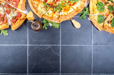 Evde ya da restoranda servis edilen üç çeşit pizza. İçinde pişirme malzemeleri, domates, fesleğen, ıspanak, roka klasik pepperoni pizza, vejetaryen sebze ve deniz ürünleri karidesli pizza var., 