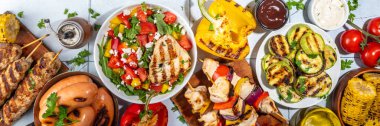 Izgara yaz bbq tabakları. Barda piknik pikniği çeşitli ızgara yiyeceklerle - şiş kebap şiş şiş, ızgara mısır, kızarmış tavuk salata, biftek, sosis, sebze
