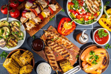 Izgara yaz bbq tabakları. Barda piknik pikniği çeşitli ızgara yiyeceklerle - şiş kebap şiş şiş, ızgara mısır, kızarmış tavuk salata, biftek, sosis, sebze